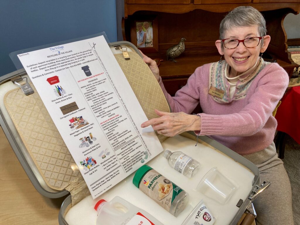 Joan Bouchard, The Village at Penn State recycling committee’s Recycling Buddy, shows the poster of what can and cannot be recycled.