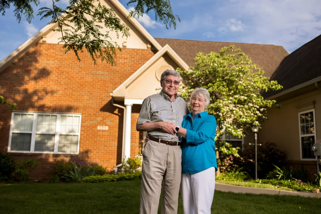 Couple stands in front of a luxury cottage at The Village at Penn State in State College, PA.