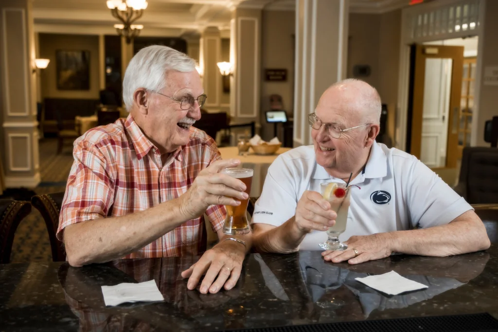 Two residents raise glasses at The Village at Penn State bar.